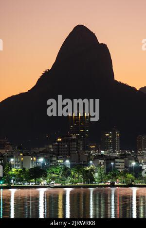 Coucher de soleil au lagon Rodrigo de Freitas avec Two Hill Brother en arrière-plan à Rio de Janeiro, Brésil. Banque D'Images