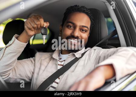 homme indien souriant ou chauffeur montrant la clé de la voiture Banque D'Images