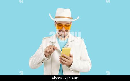 Homme souriant en été porter à l'aide d'un téléphone portable moderne Banque D'Images