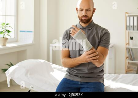 L'homme blessé a été mis sur un bandage médical pour son poignet à l'hôpital après avoir reçu une blessure au bras. Banque D'Images