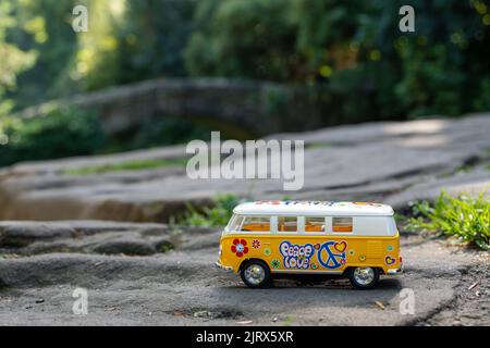 Jaune VW Camper van modèle de bus, dans une scène de nature, sur un rocher. Banque D'Images