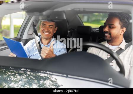 un instructeur et un chauffeur souriant de l'école de conduite automobile Banque D'Images