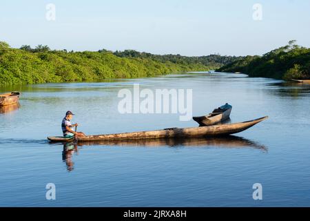 Vue d'un pêcheur pagayant le canoë vers la jetée de la rivière Banque D'Images