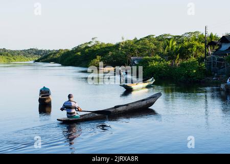 Vue d'un pêcheur pagayant le canoë vers la jetée de la rivière Banque D'Images