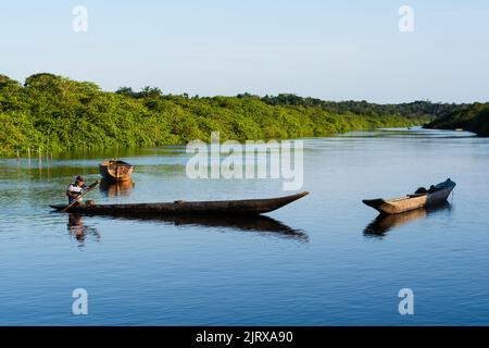 Vue d'un pêcheur pagayant le canoë vers la jetée de la rivière Banque D'Images