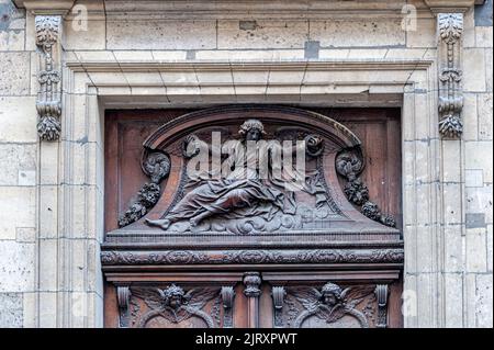 Panneau sculpté au-dessus des portes d'entrée de la crypte Saint Germain, 23 rue des Bernardines. Paris, France. Banque D'Images