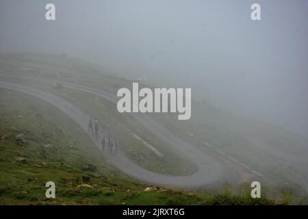 Srinagar, Cachemire, Inde. 26th août 2022. Les hommes de Kashmiri marchent le long d'une route pendant le temps brumeux à la périphérie de Srinagar. Des pluies légères à modérées ont continué à lamer Cachemire et le Département météorologique a prédit des averses légères à modérées assez répandues dans les 24 prochaines heures. (Credit image: © Saqib Majeed/SOPA Images via ZUMA Press Wire) Credit: ZUMA Press, Inc./Alamy Live News Banque D'Images