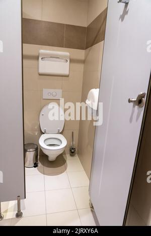 Armoire de toilettes vide avec porte ouverte dans une salle de toilettes publique Banque D'Images