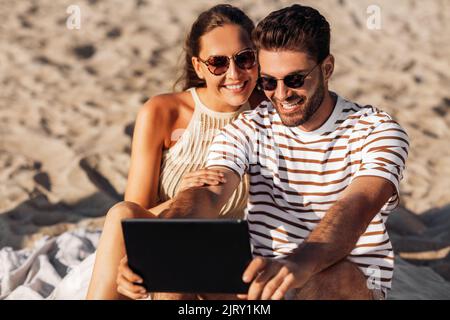 je vous souhaite un couple heureux avec un tablet pc sur la plage d'été Banque D'Images