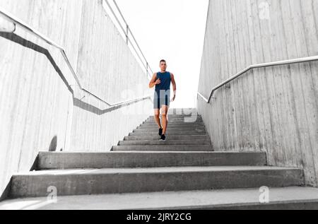 jeune homme courant au rez-de-chaussée Banque D'Images