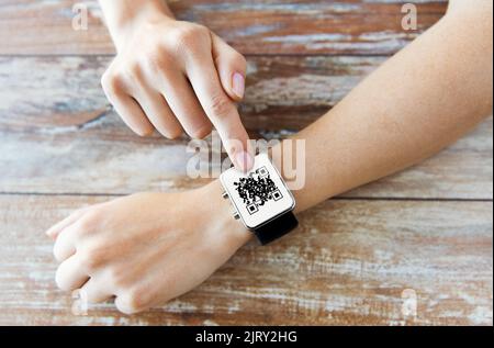 mains de femme avec code qr sur la montre intelligente Banque D'Images