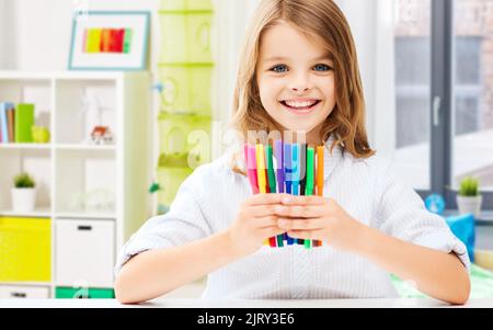 fille étudiante souriante avec stylos-feutres à la maison Banque D'Images