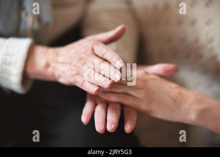 Femme âgée tenant les mains avec sa fille Banque D'Images