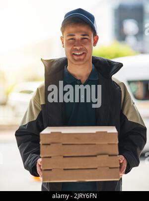 Eh bien, prenez votre repas pour vous, toujours frais et chaud. Portrait d'un jeune homme qui fait une livraison de pizza. Banque D'Images
