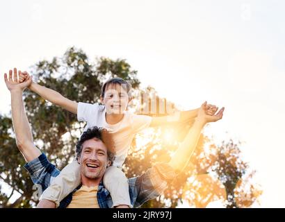 Papa ne me dit pas comment vivre, il me montre. Portrait d'un père heureux portant son jeune fils sur ses épaules à l'extérieur. Banque D'Images