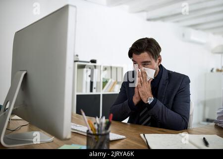 J'aurais dû prendre un jour de maladie. Un homme d'affaires souffrant d'allergies dans un bureau. Banque D'Images