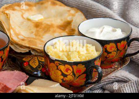Petit déjeuner au lit pour votre bien-aimé, crêpes à la crème aigre, fromage et viande, porridge de maïs et une tasse de thé fraîchement infusé. Bonjour ! Banque D'Images