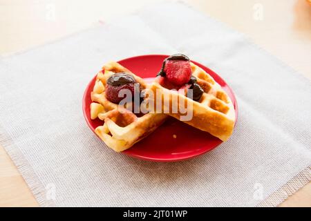 Gaufres viennoises avec fraises et chocolat sur l'assiette Banque D'Images