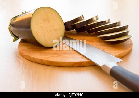 tranches de cercles d'aubergines sur le plan de coupe et le couteau du chef Banque D'Images