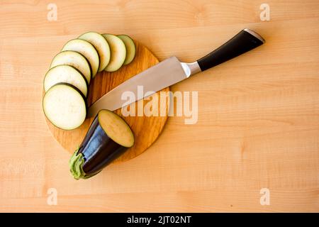 tranches de cercles d'aubergines sur le plan de coupe et le couteau du chef Banque D'Images