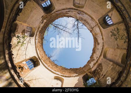 Ciel bleu vu à travers l'ancienne tour endommagée avec des fenêtres et pas de toit. Ruines de l'église abandonnée à Lubycza Klolewska. Tir horizontal. Photo de haute qualité Banque D'Images