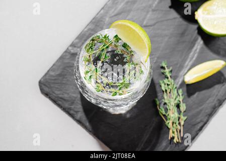 Boisson alcoolisée avec vue tonique et citron vert d'en haut. Fond gris sous béton Banque D'Images