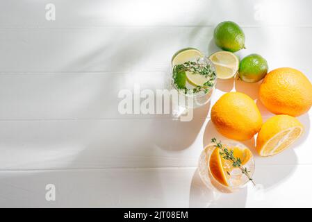 Cocktails de seltzer puissants avec citron vert et cocktails de seltzer durs boisson alcoolisée avec tonique et orange sur fond clair. Vue de dessus Banque D'Images