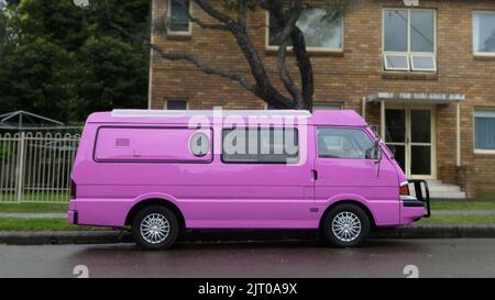 vue latérale d'une camionnette de camping rose garée à l'extérieur dans la rue devant le bâtiment Banque D'Images