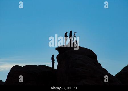 Silhouette d'un groupe de photographes dans un atelier de photo prenant des photos dans le parc national de Canyonlands dans l'Utah. Banque D'Images