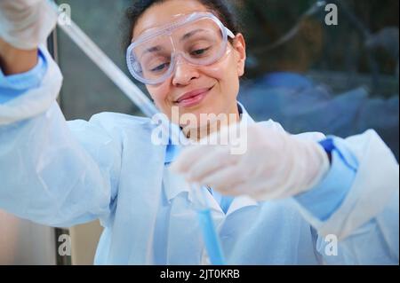 Un biologiste médical scientifique utilisant une pipette, goutte le réactif dans une éprouvette, effectue des travaux de recherche clinique sur le nouveau vaccin Banque D'Images