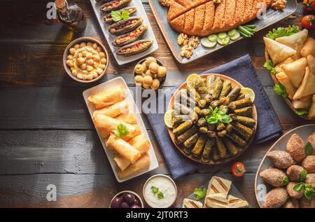 Cuisine arabe ; plats traditionnels du Moyen-Orient et meze variés. Feuilles de vigne, kibbeh, fatteh de poulet, rouleaux de printemps, sambusak, kibbeh et makdous. Banque D'Images