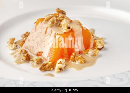 Dessert traditionnel à la citrouille avec tahini et noix sur une assiette en porcelaine blanche Banque D'Images