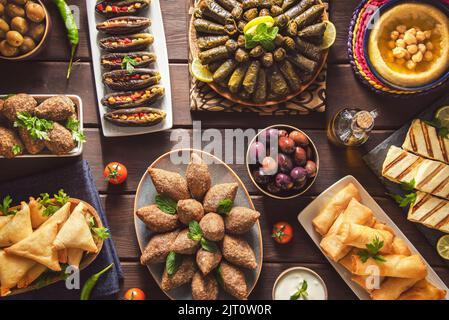 Cuisine arabe ; plats traditionnels du Moyen-Orient et meze variés. Feuilles de vigne, kibbeh, fatteh de poulet, rouleaux de printemps, sambusak, kibbeh et makdous. Banque D'Images