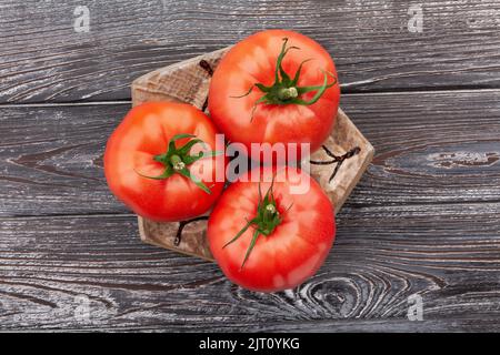 tomate sur une assiette sur fond de bois Banque D'Images