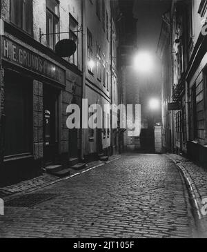 Dans le 1950s. Vue en soirée sur une rue avec des maisons anciennes. Banque D'Images