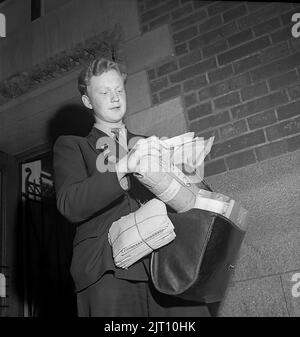 1940s mailman. Le poste est prêt à être livré et le jeune mailman a son sac plein de lettres et de colis. Angleterre 1946 Kristoffersson U94-1 Banque D'Images