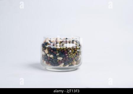 mélange de grains dans un bol en verre sur blanc Banque D'Images