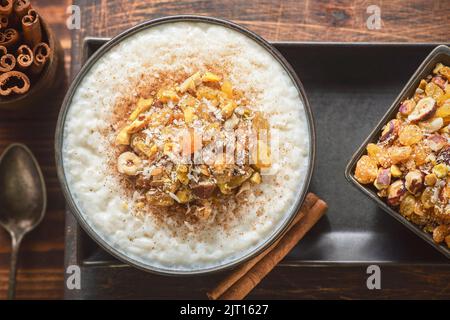 Cuisine arabe ; délicieux riz crémeux au Moyen-Orient, recouvert de cannelle et de noix. Banque D'Images