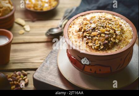 Cuisine arabe ; dessert égyptien traditionnel « Om Ali » ou « Umm Ali » de pain trempé, de lait et d'une charge de noix grillées et de raisins secs. Vue de dessus avec gros plan. Banque D'Images