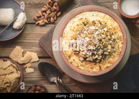 Cuisine arabe ; dessert égyptien traditionnel « Om Ali » ou « Umm Ali » de pain trempé, de lait et d'une charge de noix grillées et de raisins secs. Vue de dessus avec gros plan. Banque D'Images