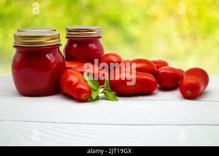 Sauce tomate italienne traditionnelle dans un pot en verre avec tomates fraîches et basilic. Copier l'espace. Banque D'Images