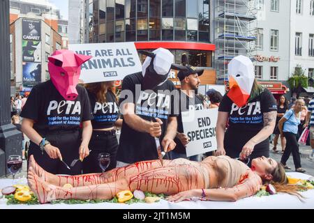 Londres, Royaume-Uni. 27th août 2022. Les militants du PETA (People for the Ethical Treatment of Animals) portant des masques pour animaux 'Dine' sur un activiste couvert de faux sang lors de la manifestation à Leicester Square. L'action, marquant la Journée mondiale pour la fin du spéciéisme, fait partie de la campagne en cours du PETA pour mettre fin au spéciéisme et encourager les gens à aller végétalien. (Photo de Vuk Valcic/SOPA Images/Sipa USA) crédit: SIPA USA/Alay Live News Banque D'Images