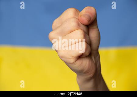 Une femme poing sur le fond du drapeau national de l'Ukraine, la force et la colère d'une femme ukrainienne contre la Russie, la guerre en Ukraine, nous ar Banque D'Images