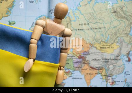 Drapeau d'Etat jaune-bleu de l'Ukraine et un homme en bois sur le fond de la carte de la Russie, arrêter la guerre et la paix en Ukraine 2022 Banque D'Images