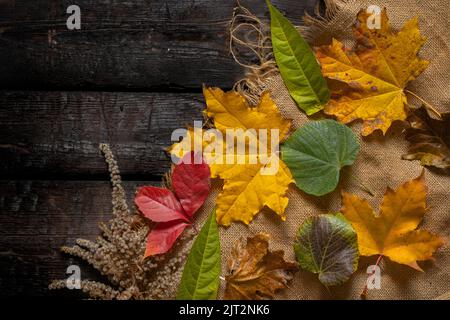 feuilles d'automne sur bois et toile de jute pour fond, fond d'automne, bois Banque D'Images