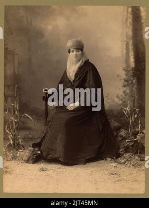 Femme turque, portrait en pied, assis, de face, tenant un parasol Banque D'Images