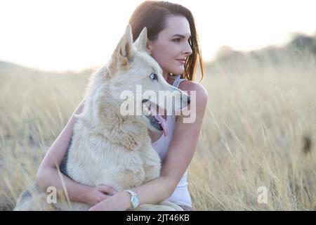 Elle est fière de son propriétaire. Une jeune femme attrayante qui se joint à son chien à l'extérieur. Banque D'Images