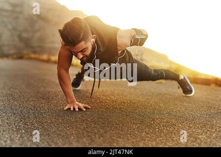 Déterminé à tuer son entraînement aujourd'hui. Un jeune homme s'exerçant à l'extérieur. Banque D'Images