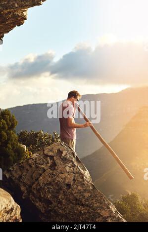 Vous serez impressionné par la beauté de la nature. Un jeune homme debout sur un sommet de montagne. Banque D'Images