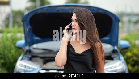 Une femme chauffeur appelle le service de voiture pour prendre la voiture pour la réparation Banque D'Images